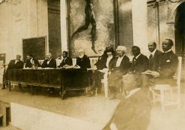 Delegates to 1921 Pan-African Congress sitting in a row on a dais